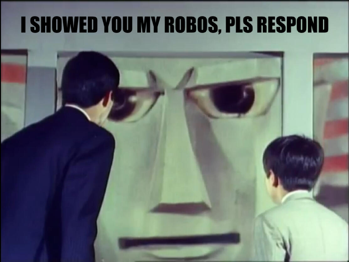 "Giant Robo" (1967) Screenshot, with Minami and Daisuke staring at Giant Robo through an elevator hatch. Giant Robo naturally has a determined, almost angry looking face with furrowed robot brows. A caption is pasted on top, reading, "showed you my robos,